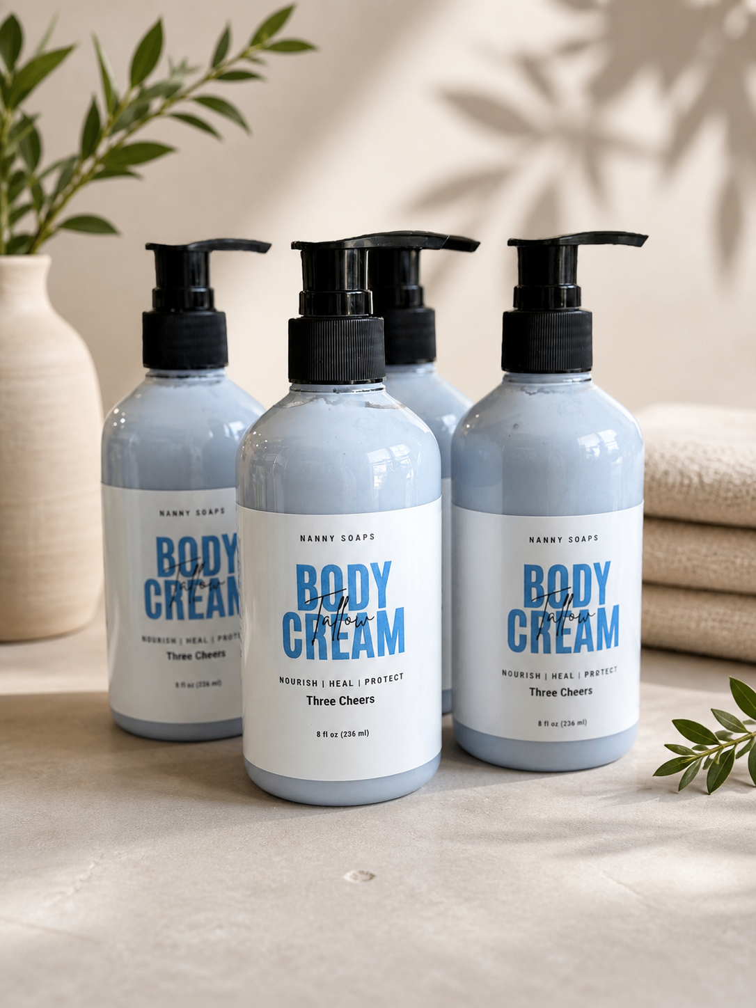 Four bottles of body cream on a wooden surface with a neutral background