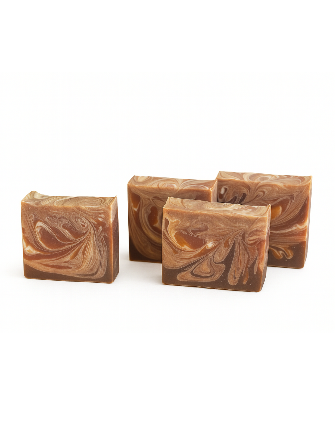 Four swirled brown and beige soap bars on a white background
