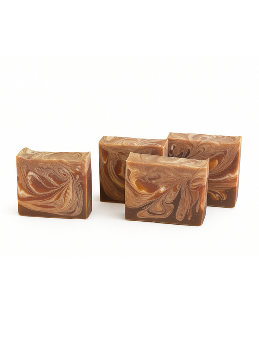 Four swirled brown and beige soap bars on a white background