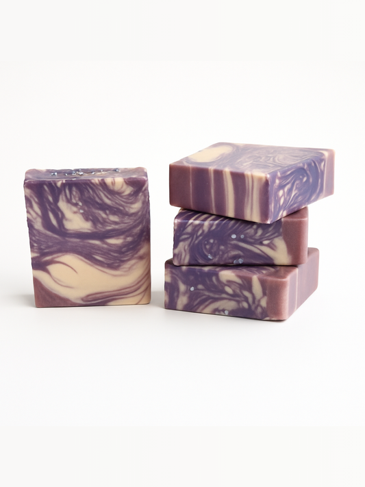 Four purple and beige soap bars on a white background.