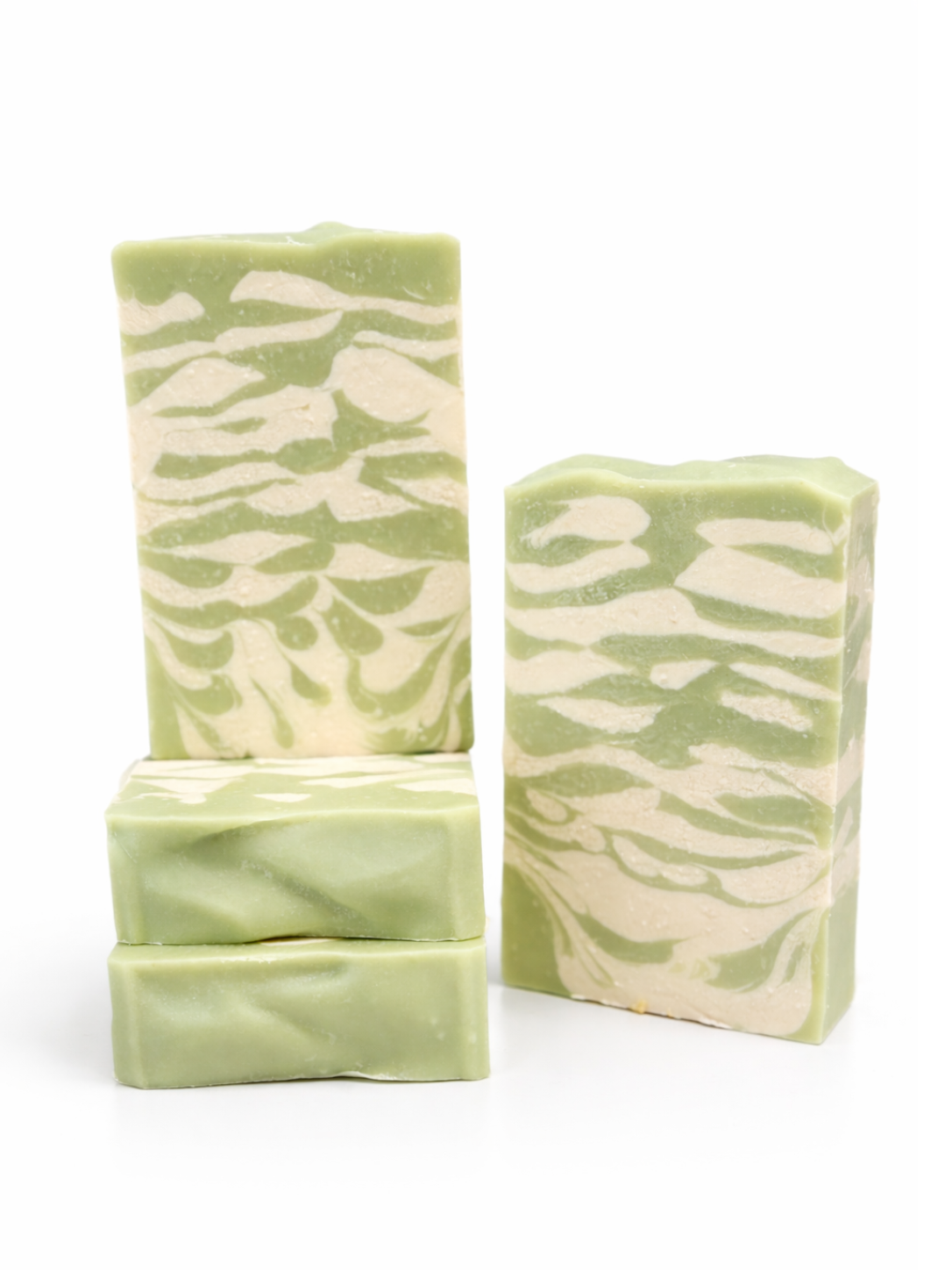 Three green and white marbled soap bars on a white background